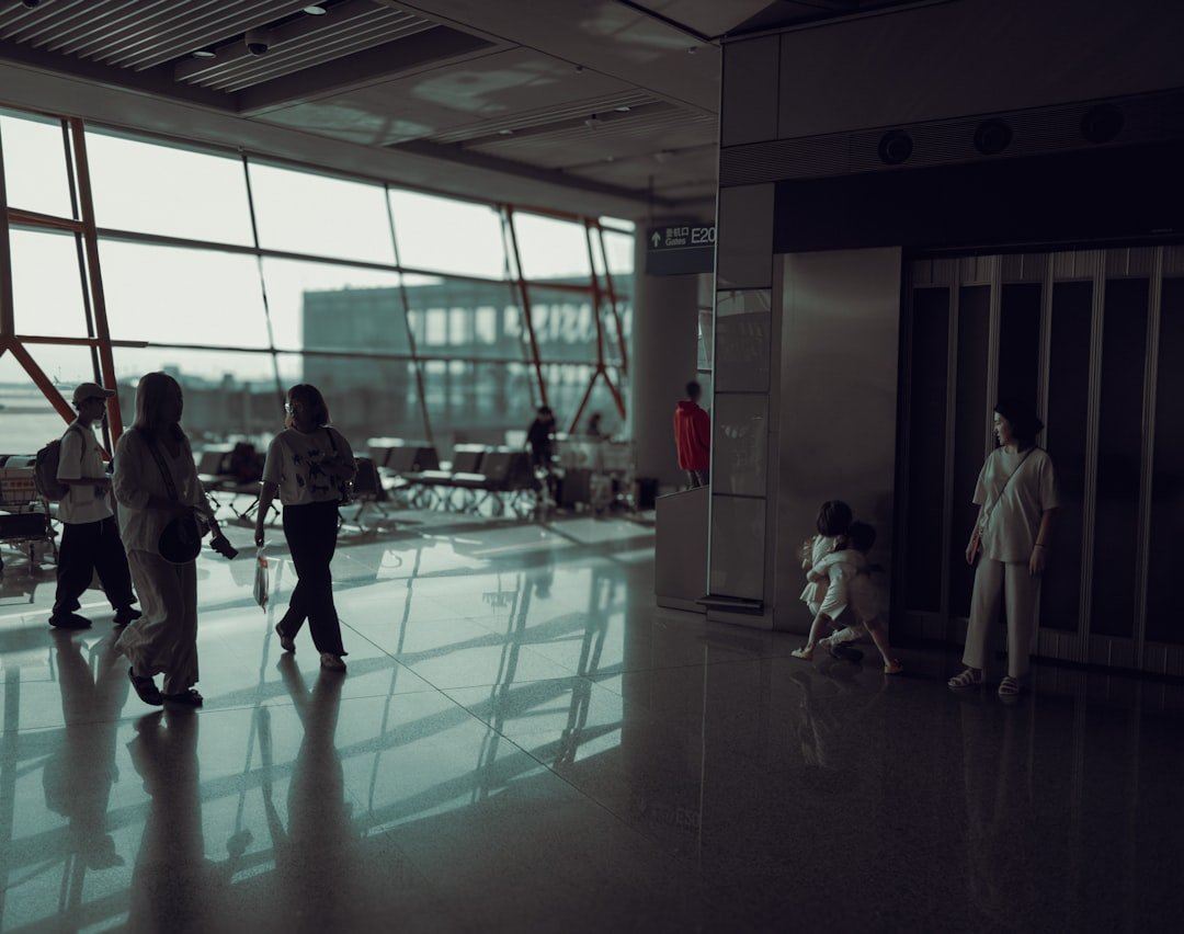 Happy family with young children walking through an airport terminal with luggage