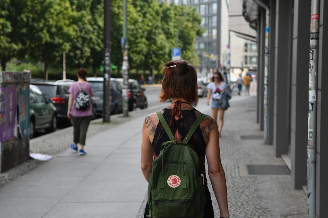 Woman backpacker confidently walking through a vibrant foreign market street with her backpack